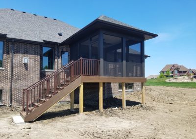 composite deck with stairway and screened in room, built with a roof extension
