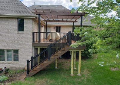 side view of second story deck with pergola and stairway