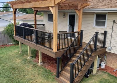 raised two-tone composite deck with pergola and stair way