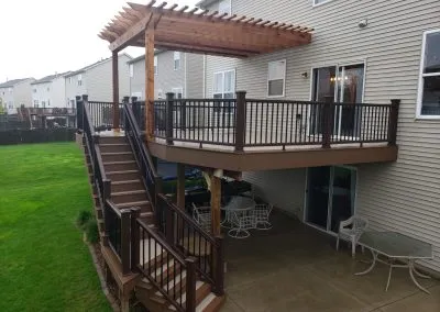 second story composite deck with pergola and stairway over lower patio