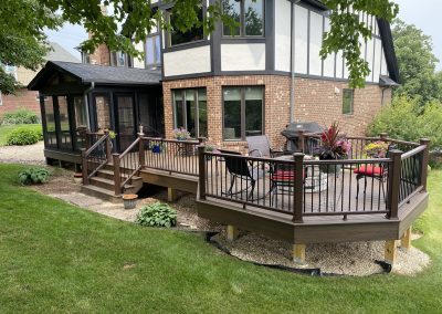 composite deck with built-in fire pit and attached screened-in room