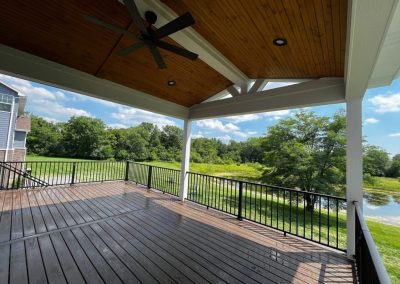 covered composite deck with wood ceiling and ceiling fan