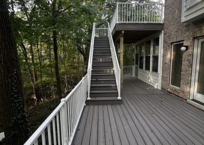 multi-level composite deck build with stairway and white railing