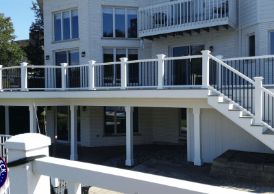 large composite deck with stairs to covered patio below