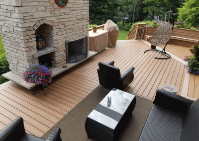 composite deck with entertaining space and integrated stone outdoor fireplace